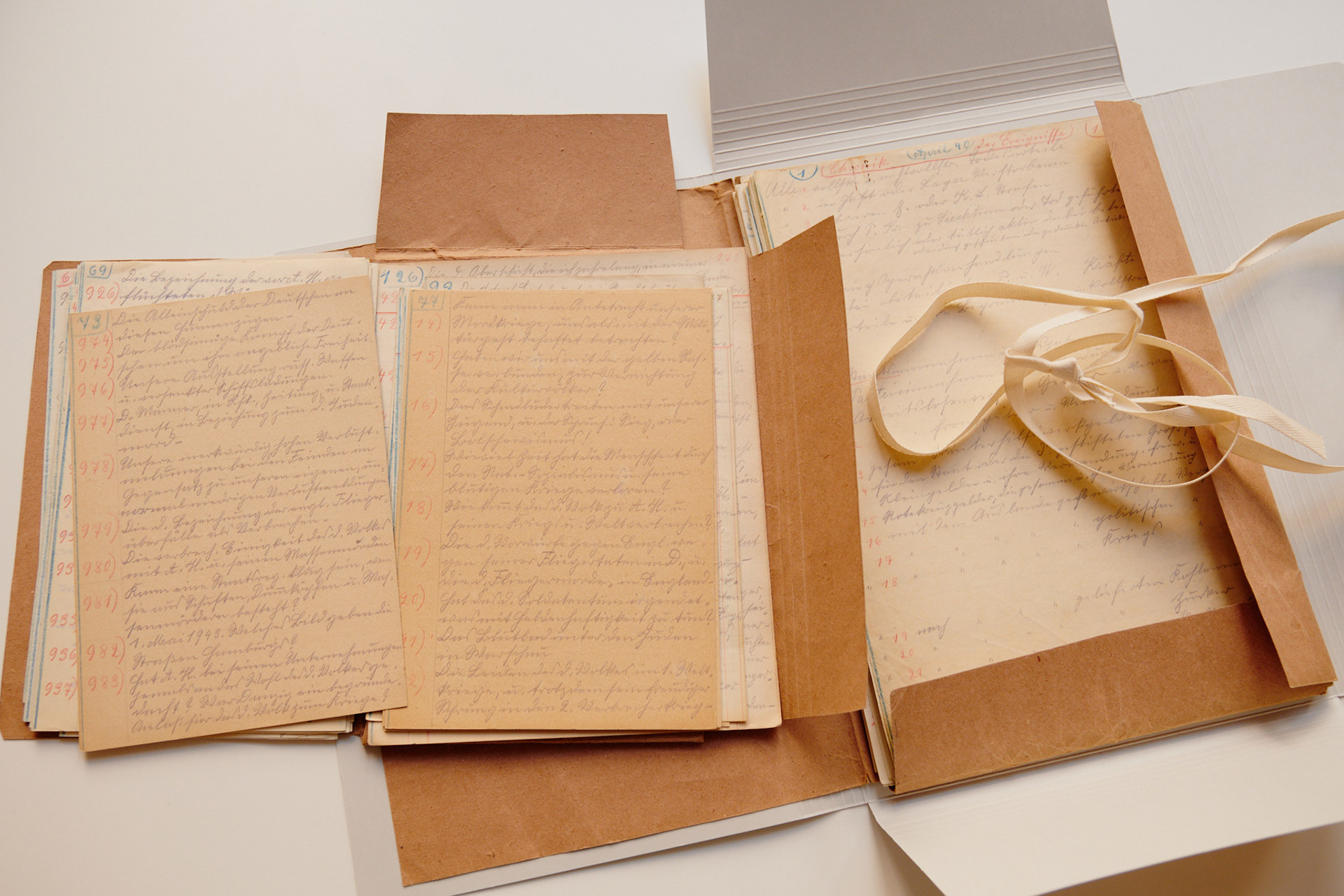 Geöffnete Mappe mit handgeschriebnen Dokumenten auf gelblichem Papier